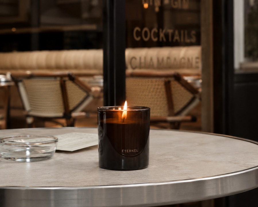 Creative variation — branded candle on a Parisian cafe table